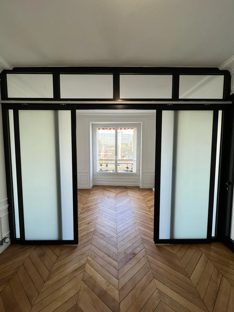 Verrière intérieure noire avec portes coulissantes et vitrages dépolis